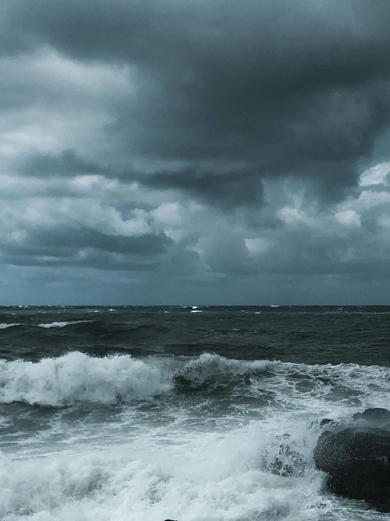 Photo de la mer agitée par les vagues avec un ciel orageux.