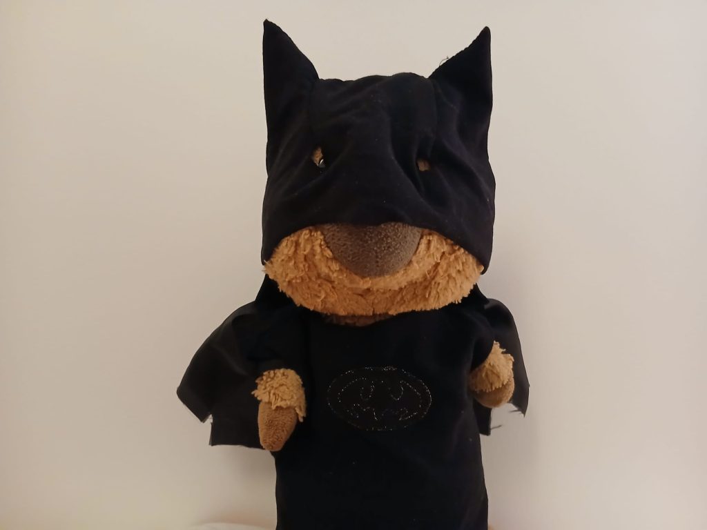 Photo d'un doudou quokka avec un costume de Batman