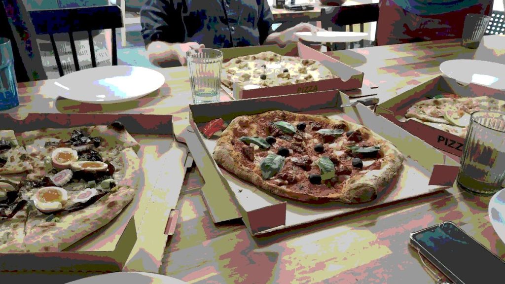 table avec des pizzas et un effet désaturé sur les couleurs