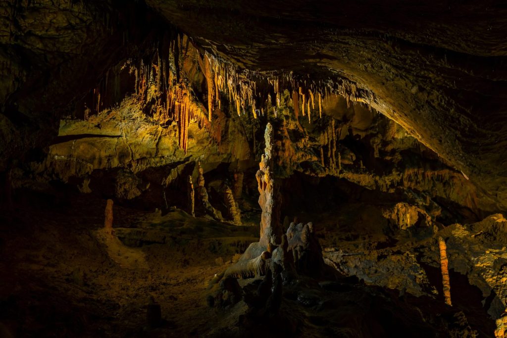 Grotte faiblement éclairée où l'on voit des stalactites