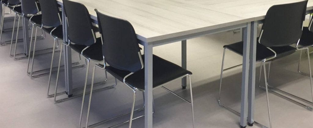Salle de réunion avec une table rectangulaire et des chaises autour