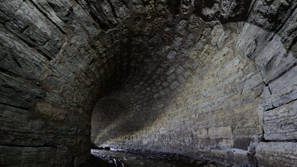 tunnel de pierre avec de l'eau au sol