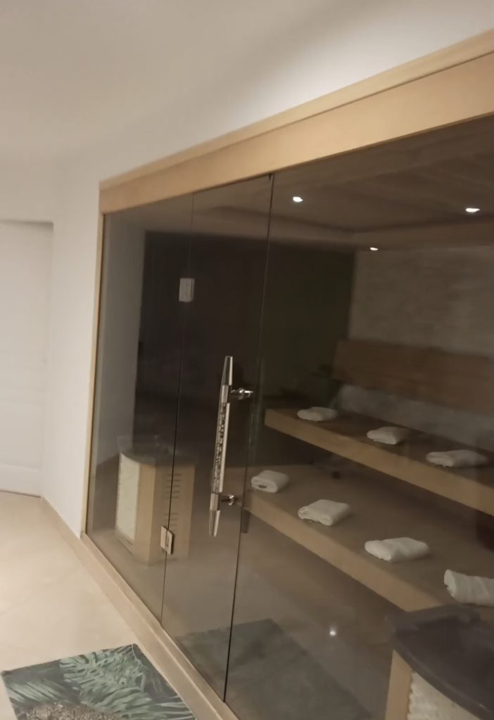 Vitre donnant sur un sauna avec un banc et des serviettes.