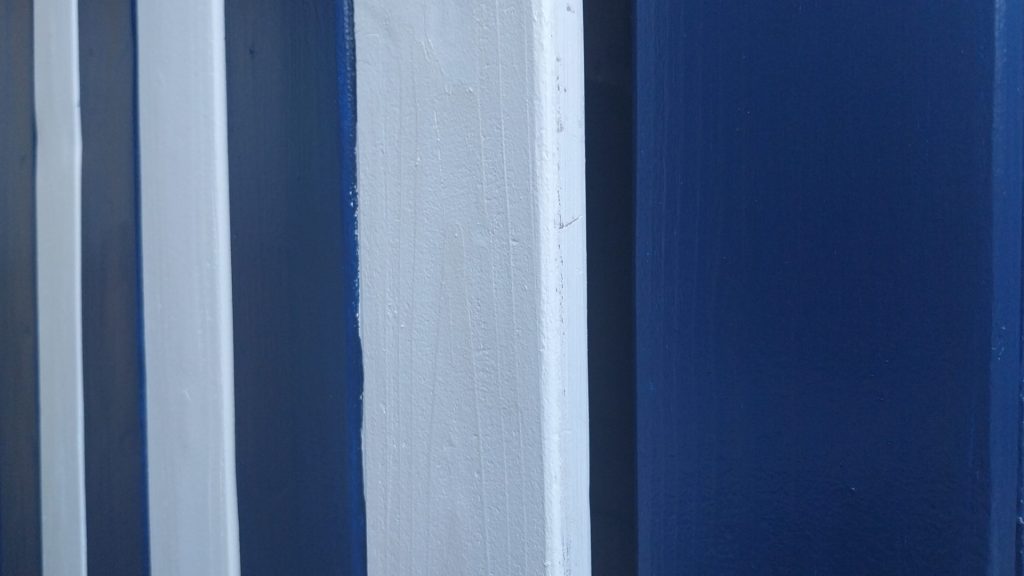 vue très rapprochée d'une porte de cabanon de plage, rayée bleue et blanche